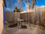Private outdoor space with seating and wood pile for kiva